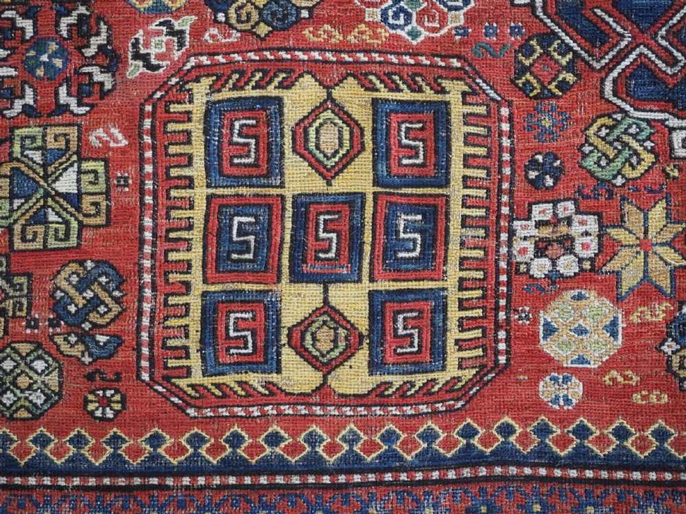 An antique Caucasian flatweave Soumak rug featuring three large geometric medallions on a red field framed by a patterned yellow border. View XIII