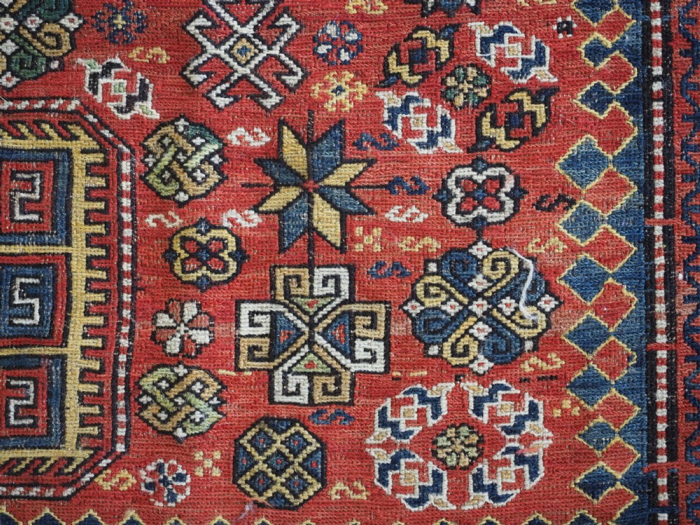 An antique Caucasian flatweave Soumak rug featuring three large geometric medallions on a red field framed by a patterned yellow border. View XIV
