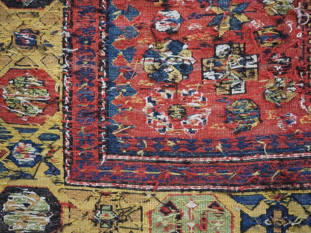An antique Caucasian flatweave Soumak rug featuring three large geometric medallions on a red field framed by a patterned yellow border. View XVI
