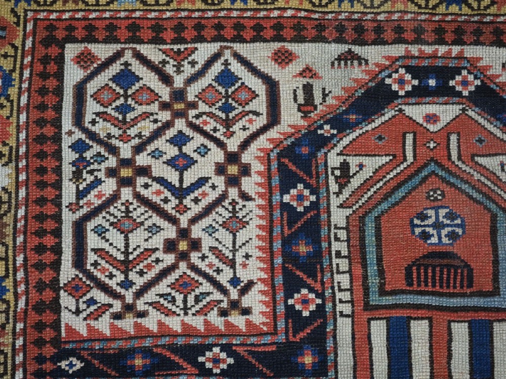 An antique Caucasian Shirvan wool prayer rug featuring an ivory field covered in a geometric floral lattice motif, enclosed by a multi-bordered frame and a stepped prayer arch at the top. View VIII
