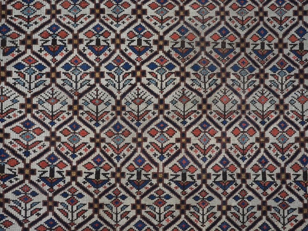 An antique Caucasian Shirvan wool prayer rug featuring an ivory field covered in a geometric floral lattice motif, enclosed by a multi-bordered frame and a stepped prayer arch at the top. View X