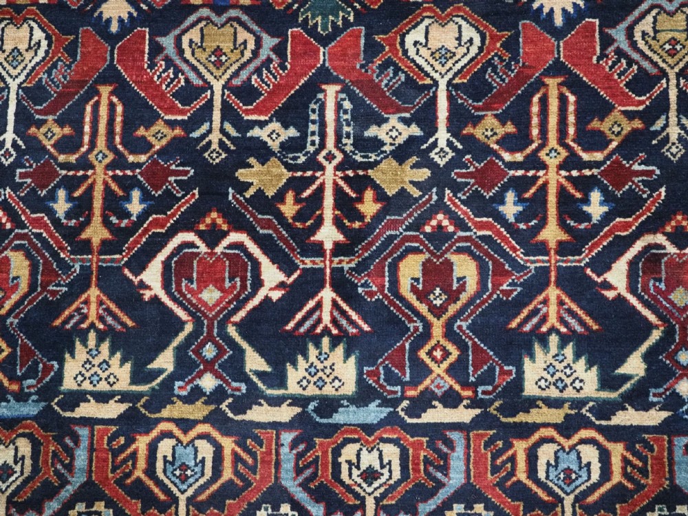 An antique handwoven wool Caucasian Kuba runner featuring dense geometric motifs in red, blue, and cream shades across a long dark navy field. View XIII