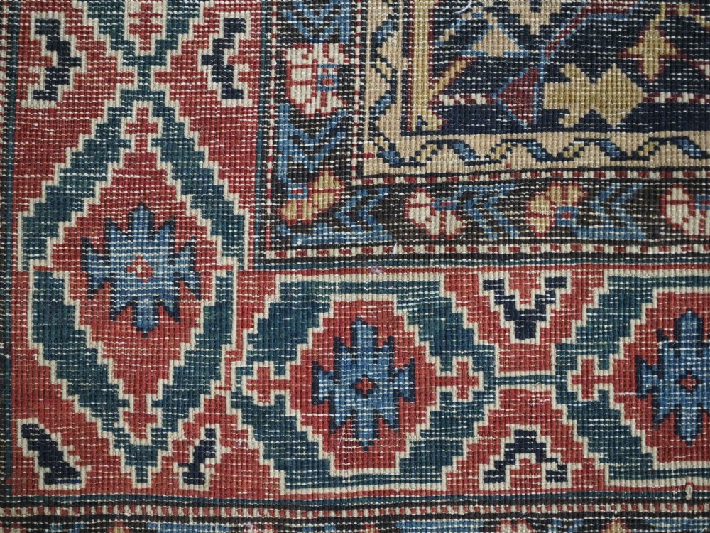 An antique handwoven wool Caucasian Kuba runner featuring dense geometric motifs in red, blue, and cream shades across a long dark navy field. View XVI