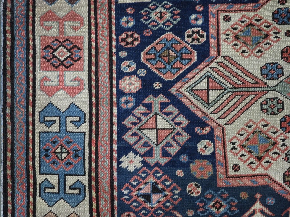 An antique Caucasian Akstafa long rug runner featuring three star medallions and stylized peacock motifs on a dark navy blue field with geometric borders. View VIII