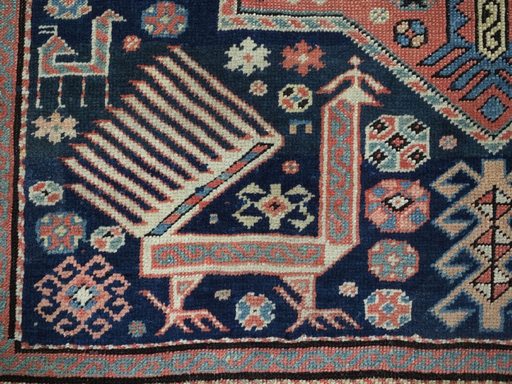 An antique Caucasian Akstafa long rug runner featuring three star medallions and stylized peacock motifs on a dark navy blue field with geometric borders. View IX