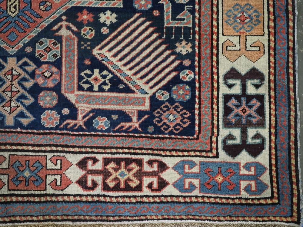 An antique Caucasian Akstafa long rug runner featuring three star medallions and stylized peacock motifs on a dark navy blue field with geometric borders. View XI