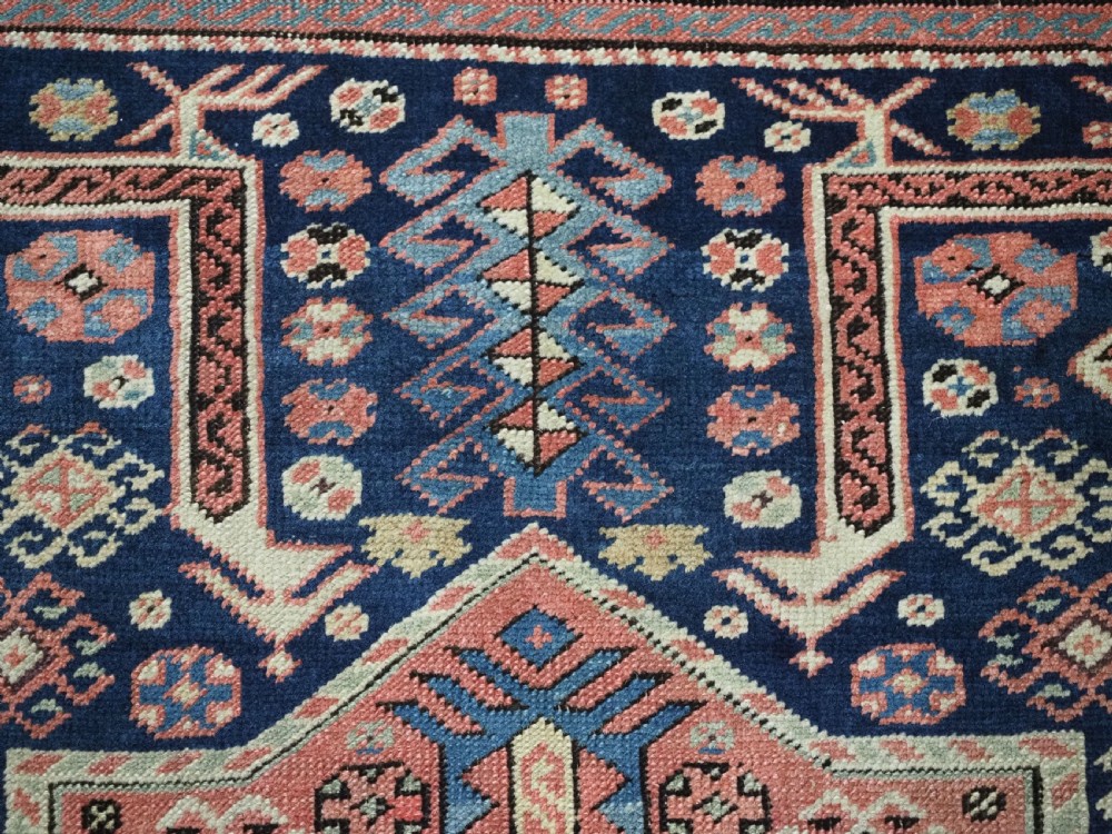 An antique Caucasian Akstafa long rug runner featuring three star medallions and stylized peacock motifs on a dark navy blue field with geometric borders. View XII