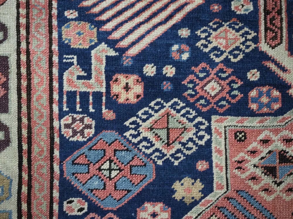 An antique Caucasian Akstafa long rug runner featuring three star medallions and stylized peacock motifs on a dark navy blue field with geometric borders. View XIII