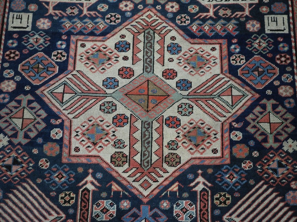 An antique Caucasian Akstafa long rug runner featuring three star medallions and stylized peacock motifs on a dark navy blue field with geometric borders. View XVI
