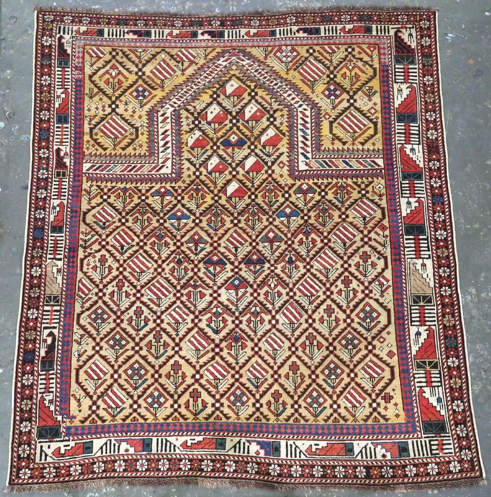 A hand-knotted Caucasian Marasali prayer rug featuring a yellow ground with a prominent pointed mihrab arch, diamond lattice patterns, and geometric borders in red, blue, and brown.