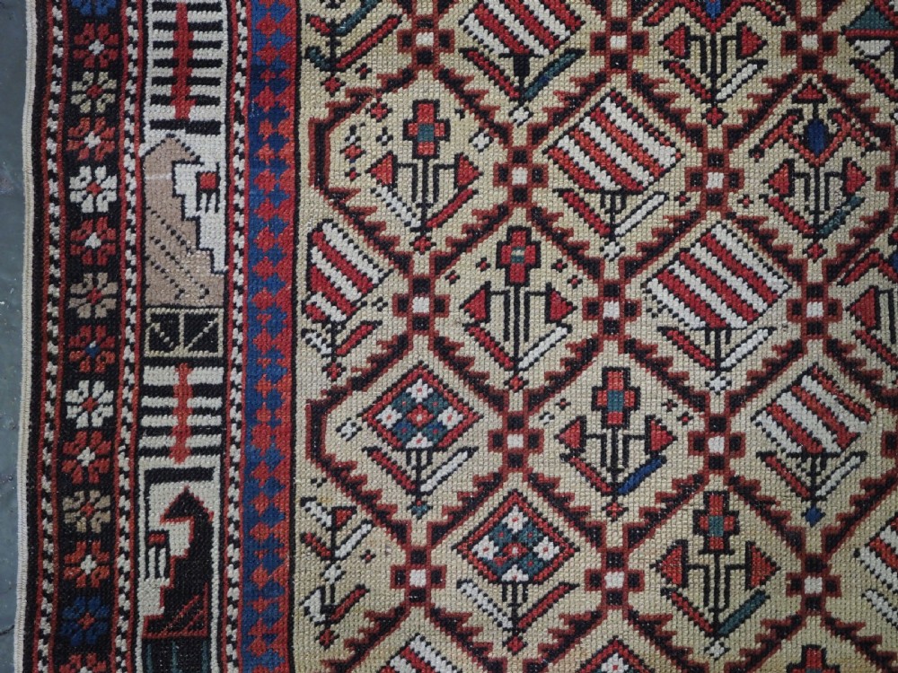 A hand-knotted Caucasian Marasali prayer rug featuring a yellow ground with a prominent pointed mihrab arch, diamond lattice patterns, and geometric borders in red, blue, and brown. View III