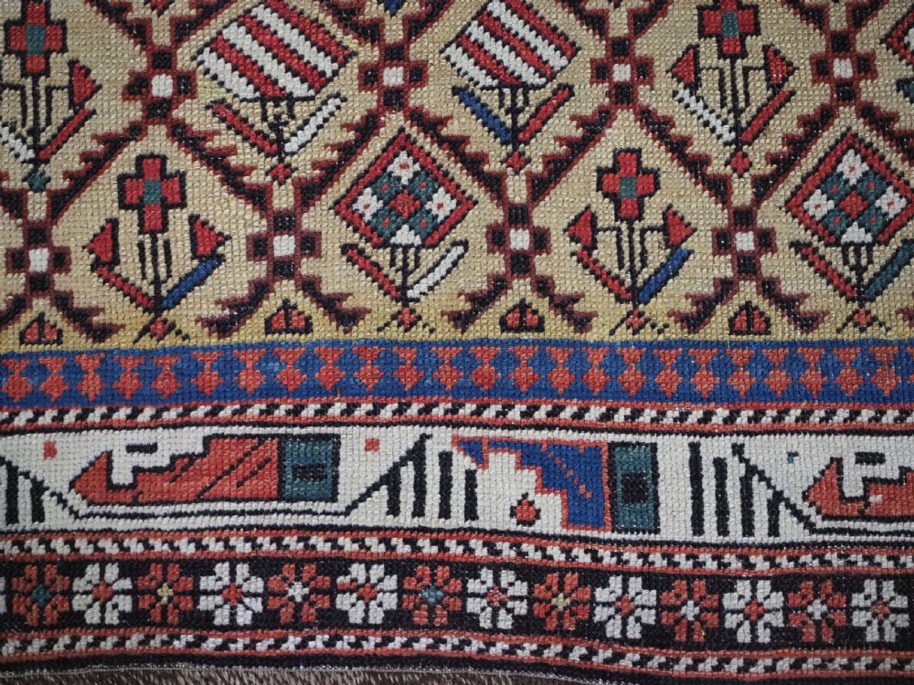 A hand-knotted Caucasian Marasali prayer rug featuring a yellow ground with a prominent pointed mihrab arch, diamond lattice patterns, and geometric borders in red, blue, and brown. View IX