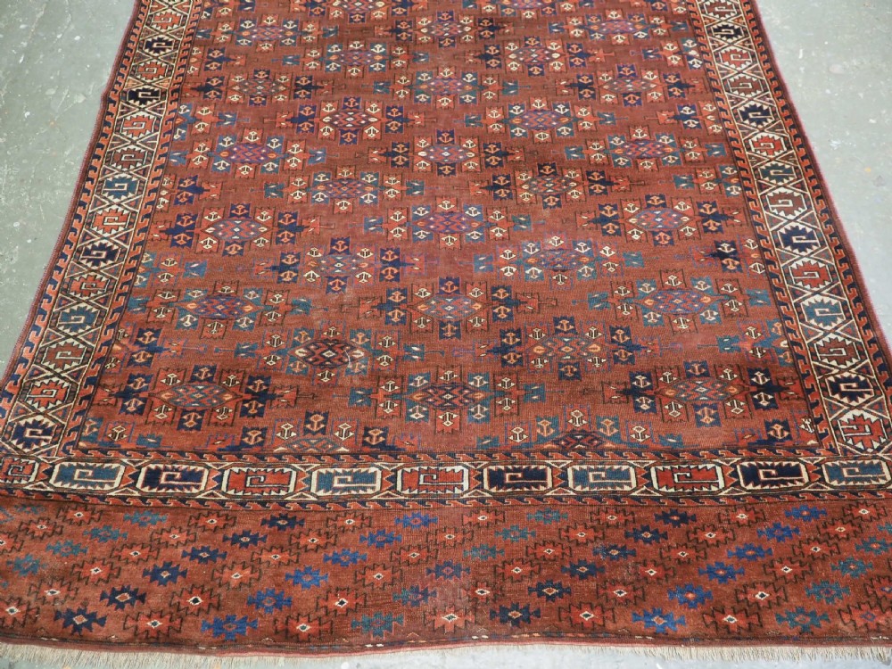 An antique Yomut Turkmen hand-knotted wool carpet featuring repeating Kepse gul geometric diamond patterns in deep red, navy, and cream. View VI