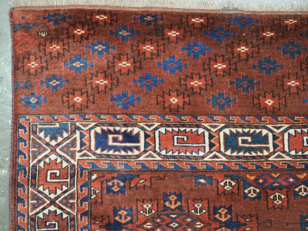 An antique Yomut Turkmen hand-knotted wool carpet featuring repeating Kepse gul geometric diamond patterns in deep red, navy, and cream. View VII
