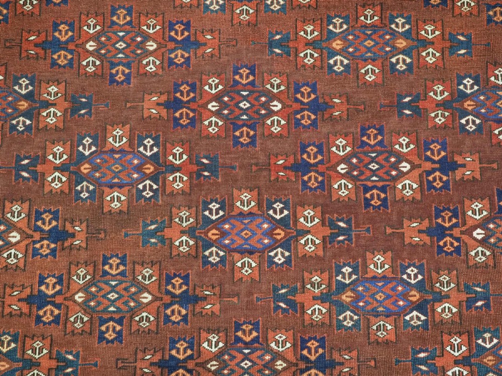 An antique Yomut Turkmen hand-knotted wool carpet featuring repeating Kepse gul geometric diamond patterns in deep red, navy, and cream. View VIII