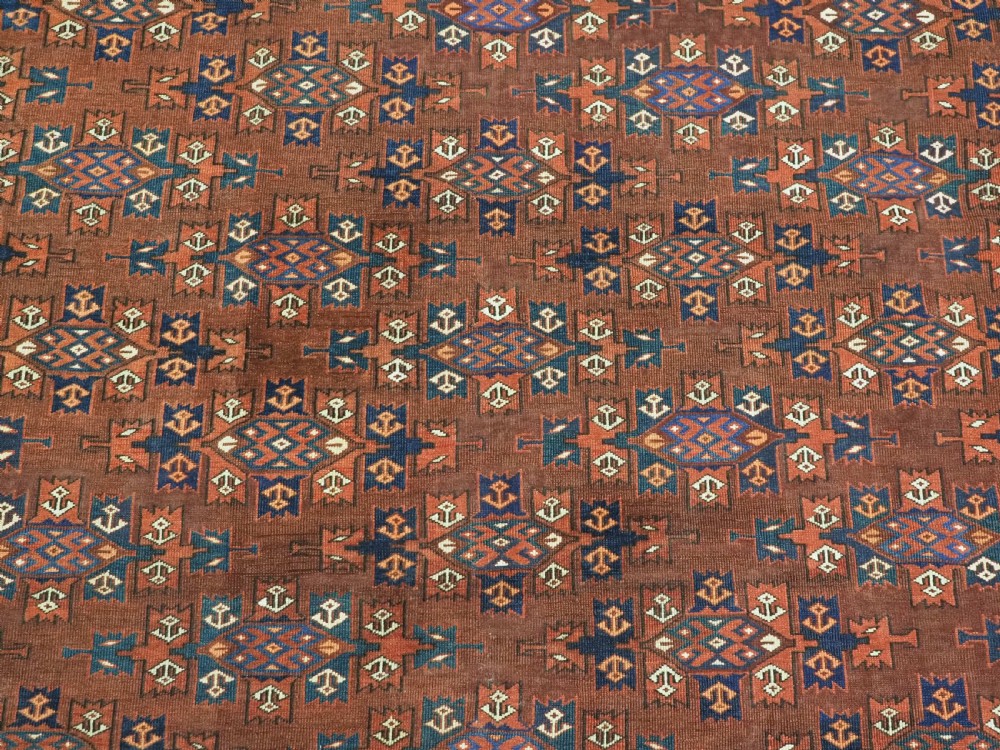 An antique Yomut Turkmen hand-knotted wool carpet featuring repeating Kepse gul geometric diamond patterns in deep red, navy, and cream. View IX