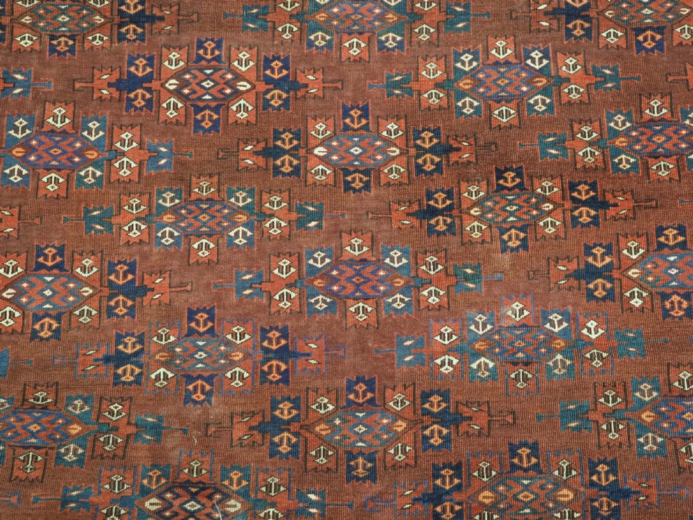An antique Yomut Turkmen hand-knotted wool carpet featuring repeating Kepse gul geometric diamond patterns in deep red, navy, and cream. View X