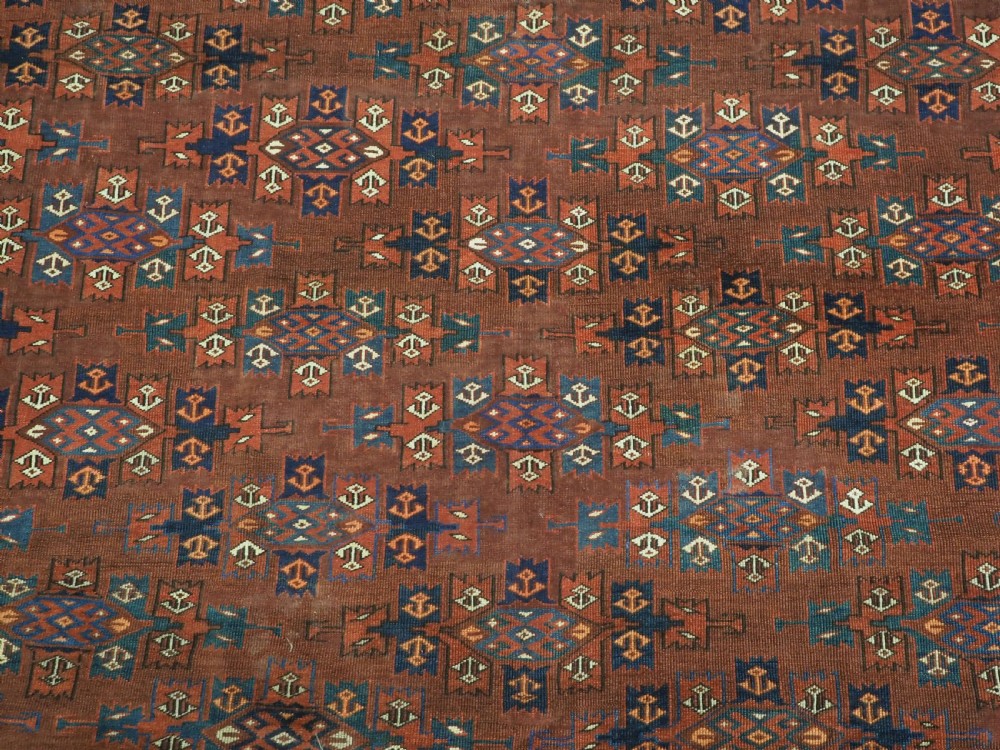 An antique Yomut Turkmen hand-knotted wool carpet featuring repeating Kepse gul geometric diamond patterns in deep red, navy, and cream. View XII