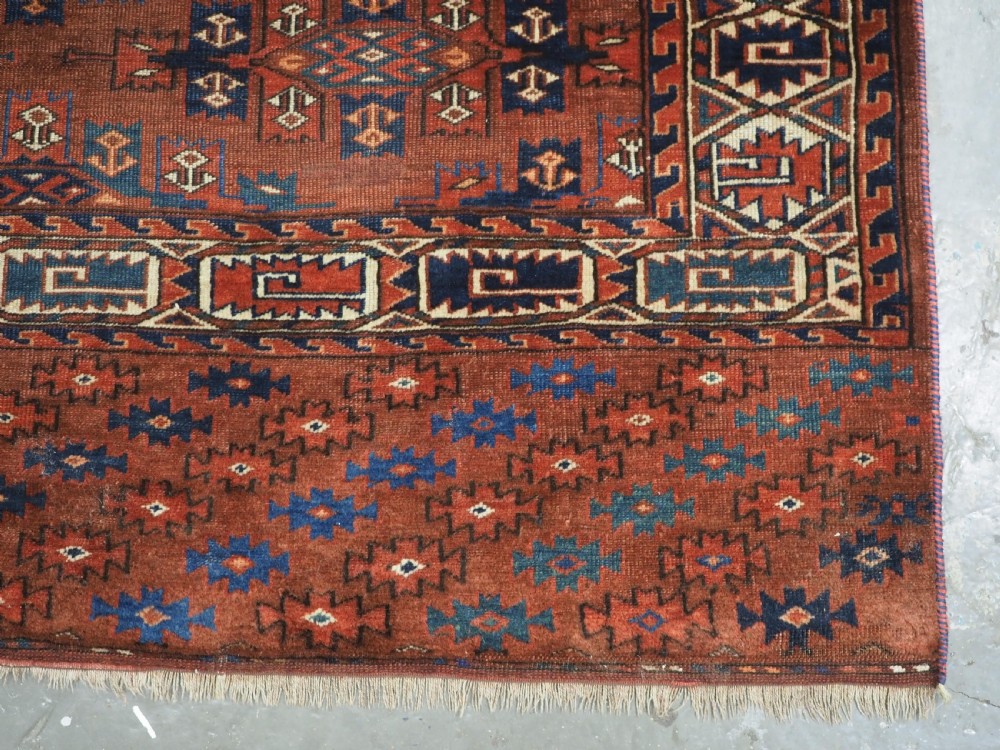 An antique Yomut Turkmen hand-knotted wool carpet featuring repeating Kepse gul geometric diamond patterns in deep red, navy, and cream. View XIV