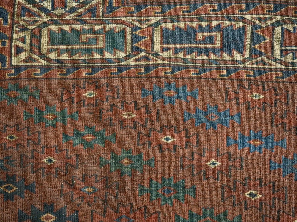 An antique Yomut Turkmen hand-knotted wool carpet featuring repeating Kepse gul geometric diamond patterns in deep red, navy, and cream. View XV