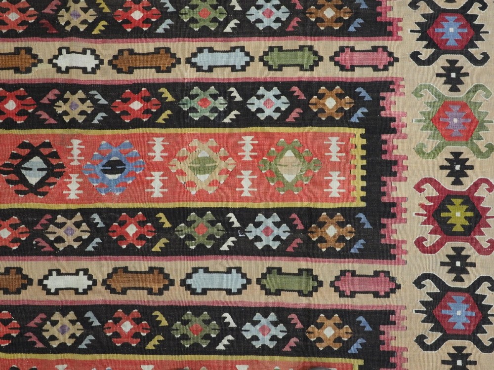 A handwoven antique Pirot Sarkoy flatweave wool kilim rug featuring horizontal bands of geometric motifs in terracotta, beige, yellow, green, and dark brown. View IX