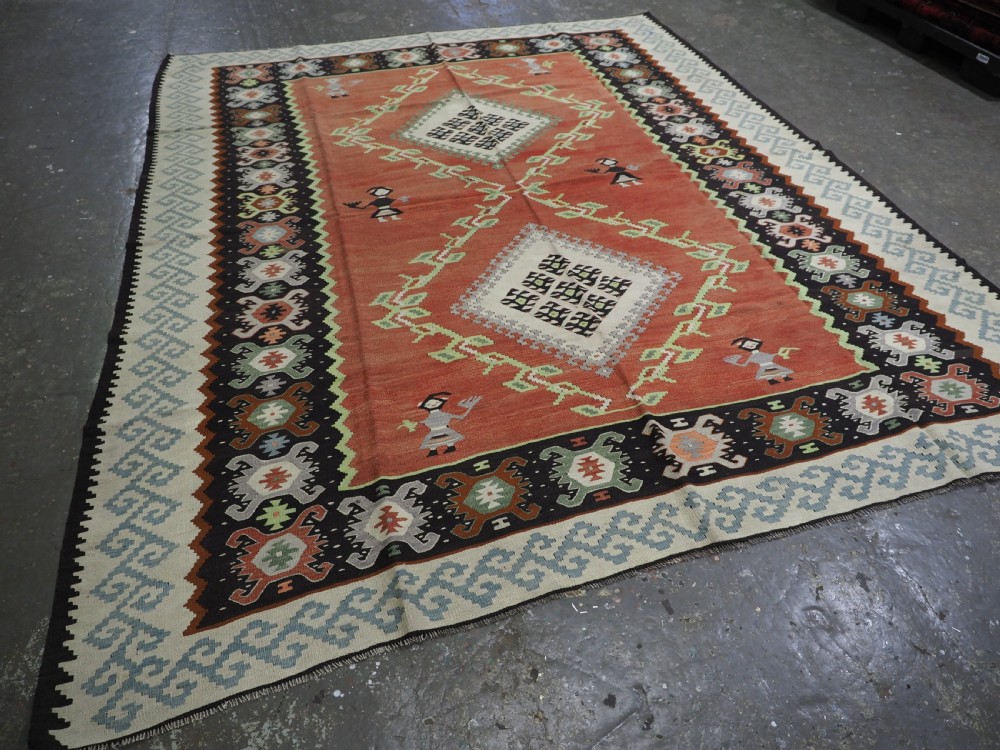 An antique woven wool Pirot Sarkoy kilim rug featuring a central terracotta red field decorated with diamond medallions and intricate geometric borders. View II