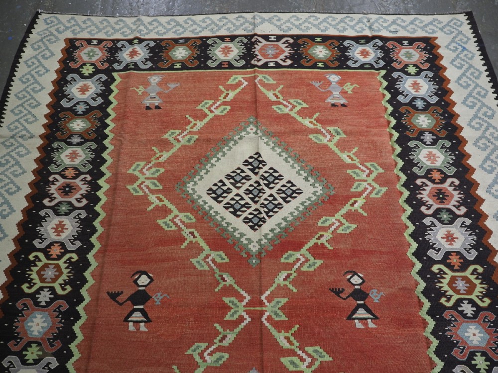 An antique woven wool Pirot Sarkoy kilim rug featuring a central terracotta red field decorated with diamond medallions and intricate geometric borders. View III