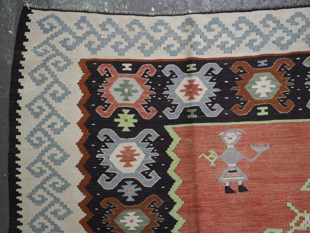 An antique woven wool Pirot Sarkoy kilim rug featuring a central terracotta red field decorated with diamond medallions and intricate geometric borders. View VI