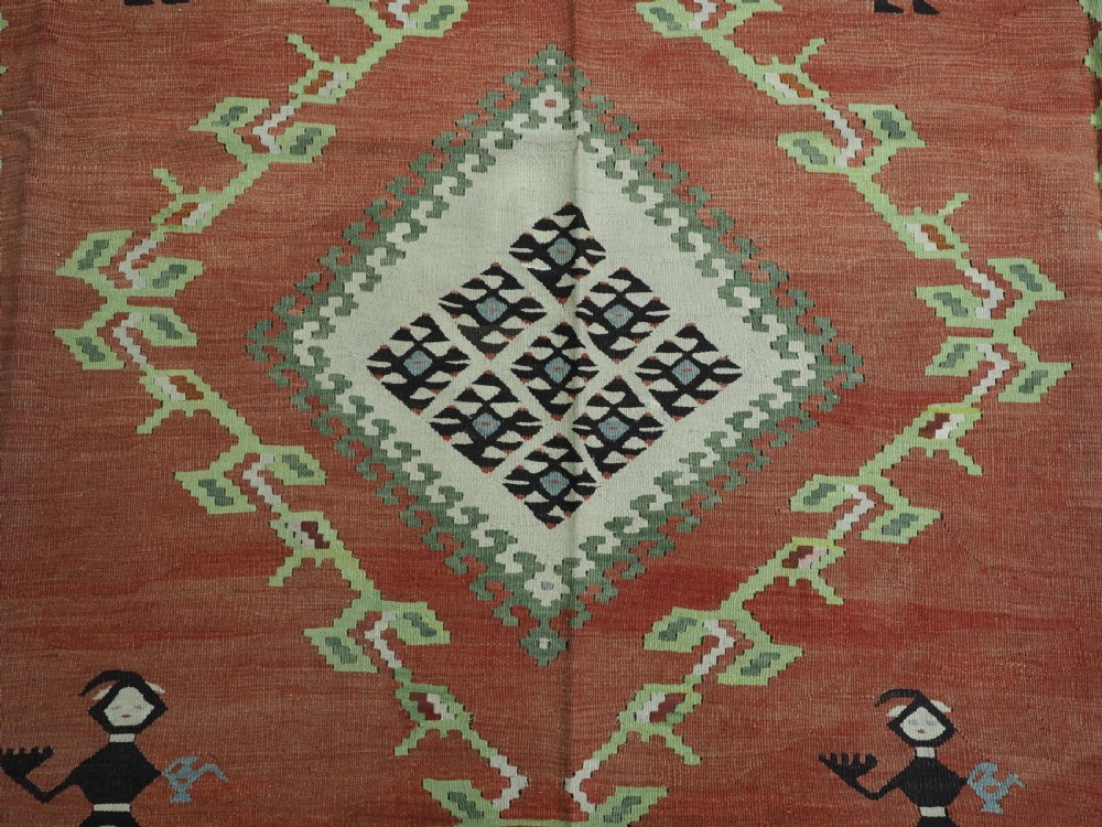 An antique woven wool Pirot Sarkoy kilim rug featuring a central terracotta red field decorated with diamond medallions and intricate geometric borders. View VIII