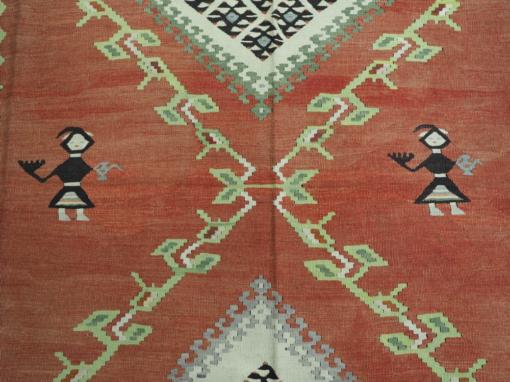 An antique woven wool Pirot Sarkoy kilim rug featuring a central terracotta red field decorated with diamond medallions and intricate geometric borders. View X