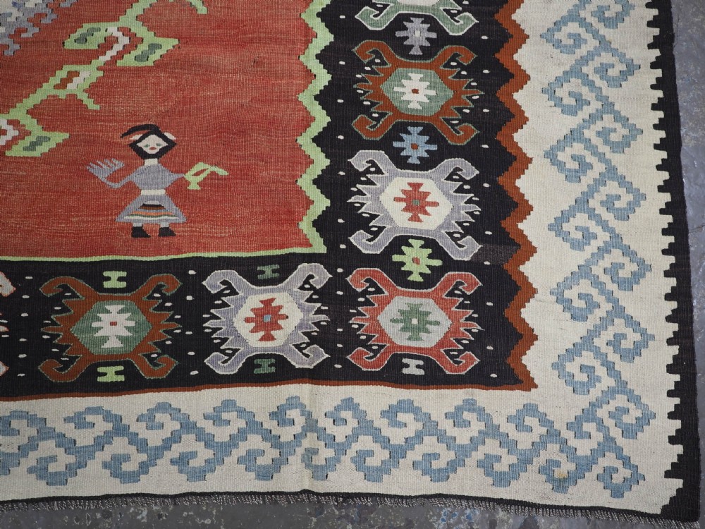 An antique woven wool Pirot Sarkoy kilim rug featuring a central terracotta red field decorated with diamond medallions and intricate geometric borders. View XIII