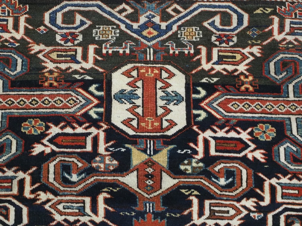 An antique hand-knotted Caucasian Perepedil rug featuring a navy blue field with geometric rams horn motifs and star medallions framed by multi-layered geometric borders. View VIII