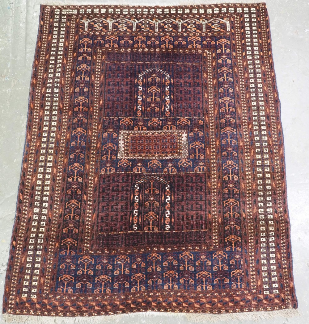 An antique 19th-century Saryk Turkmen ensi rug with a dark reddish-brown field featuring geometric cross divisions and white cotton highlights.