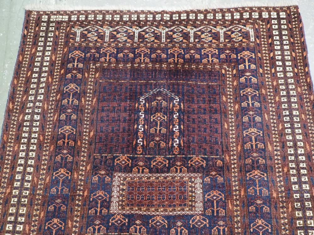 An antique 19th-century Saryk Turkmen ensi rug with a dark reddish-brown field featuring geometric cross divisions and white cotton highlights. View III