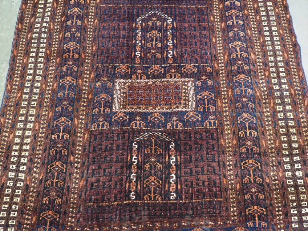 An antique 19th-century Saryk Turkmen ensi rug with a dark reddish-brown field featuring geometric cross divisions and white cotton highlights. View IV