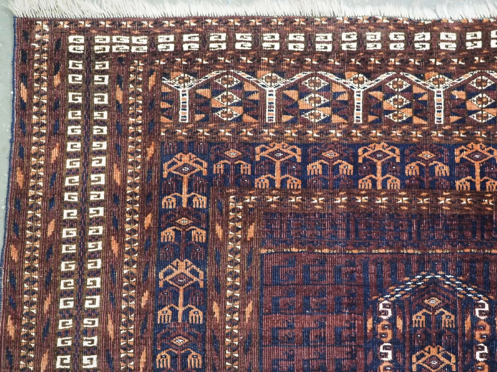 An antique 19th-century Saryk Turkmen ensi rug with a dark reddish-brown field featuring geometric cross divisions and white cotton highlights. View VI