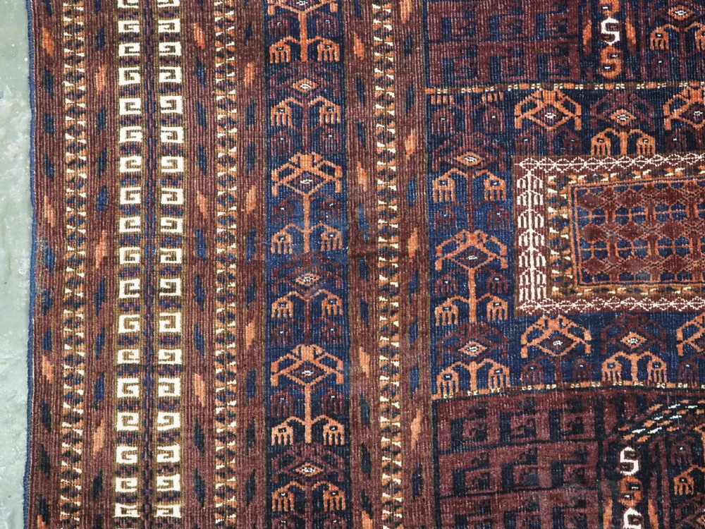 An antique 19th-century Saryk Turkmen ensi rug with a dark reddish-brown field featuring geometric cross divisions and white cotton highlights. View VII