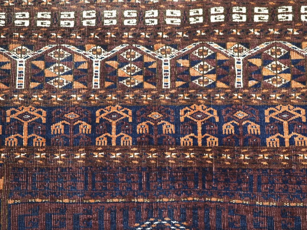 An antique 19th-century Saryk Turkmen ensi rug with a dark reddish-brown field featuring geometric cross divisions and white cotton highlights. View VIII