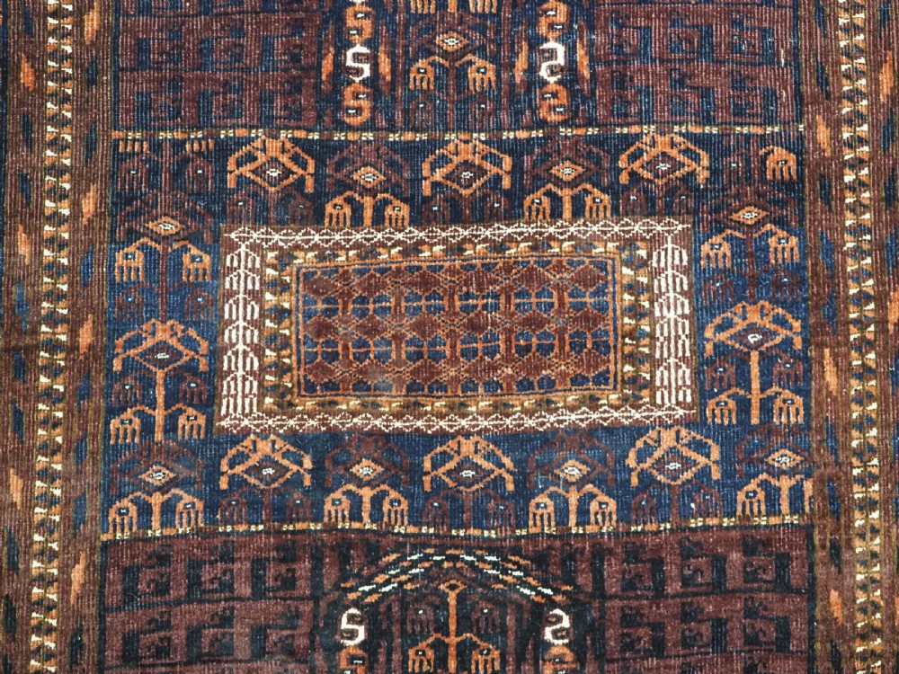 An antique 19th-century Saryk Turkmen ensi rug with a dark reddish-brown field featuring geometric cross divisions and white cotton highlights. View X
