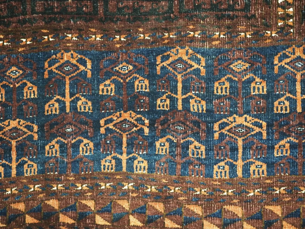 An antique 19th-century Saryk Turkmen ensi rug with a dark reddish-brown field featuring geometric cross divisions and white cotton highlights. View XII