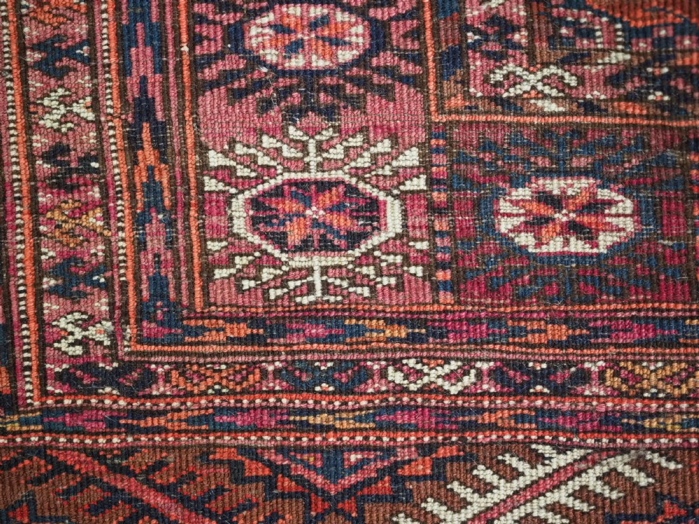An antique rectangular hand-knotted wool Tekke Turkmen rug featuring repeating octagonal gul motifs in terracotta, navy, and cream tones with geometric borders. View XI