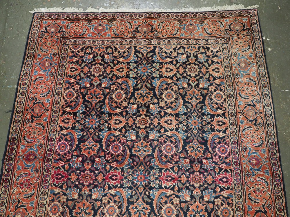 An antique hand-knotted wool Tabriz rug featuring a dense repeating Herati design in navy blue, terracotta, and beige with a multi-band decorative border. View III
