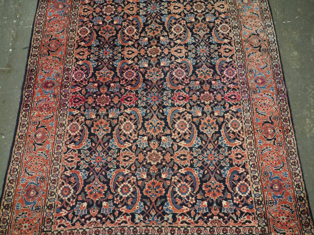 An antique hand-knotted wool Tabriz rug featuring a dense repeating Herati design in navy blue, terracotta, and beige with a multi-band decorative border. View IV