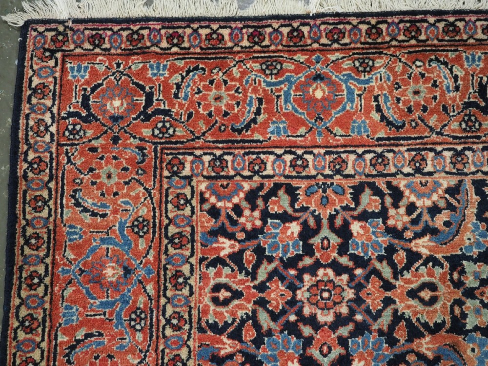 An antique hand-knotted wool Tabriz rug featuring a dense repeating Herati design in navy blue, terracotta, and beige with a multi-band decorative border. View VI