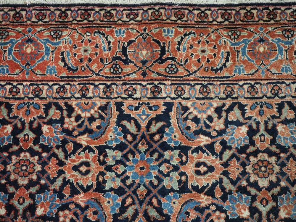 An antique hand-knotted wool Tabriz rug featuring a dense repeating Herati design in navy blue, terracotta, and beige with a multi-band decorative border. View VIII