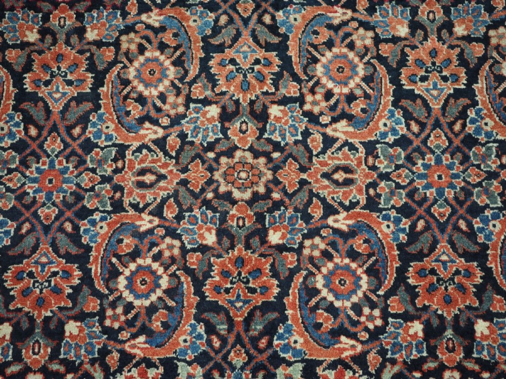 An antique hand-knotted wool Tabriz rug featuring a dense repeating Herati design in navy blue, terracotta, and beige with a multi-band decorative border. View X