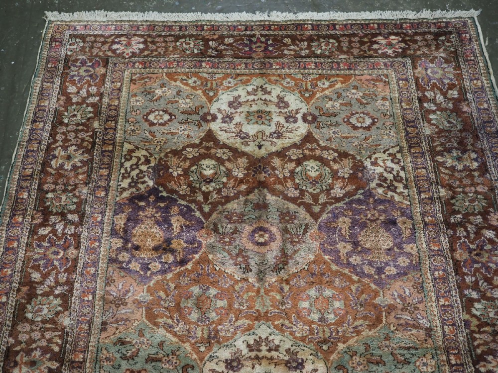 A rectangular vintage Turkish Kayseri rug featuring intricate floral lattice motifs and medallions in shades of brown, terracotta, purple, and green with a decorative bordered edge and fringed ends. View III