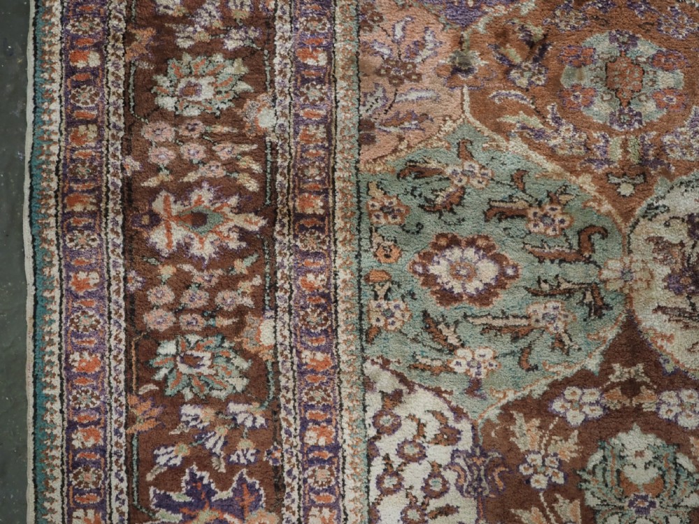 A rectangular vintage Turkish Kayseri rug featuring intricate floral lattice motifs and medallions in shades of brown, terracotta, purple, and green with a decorative bordered edge and fringed ends. View VII