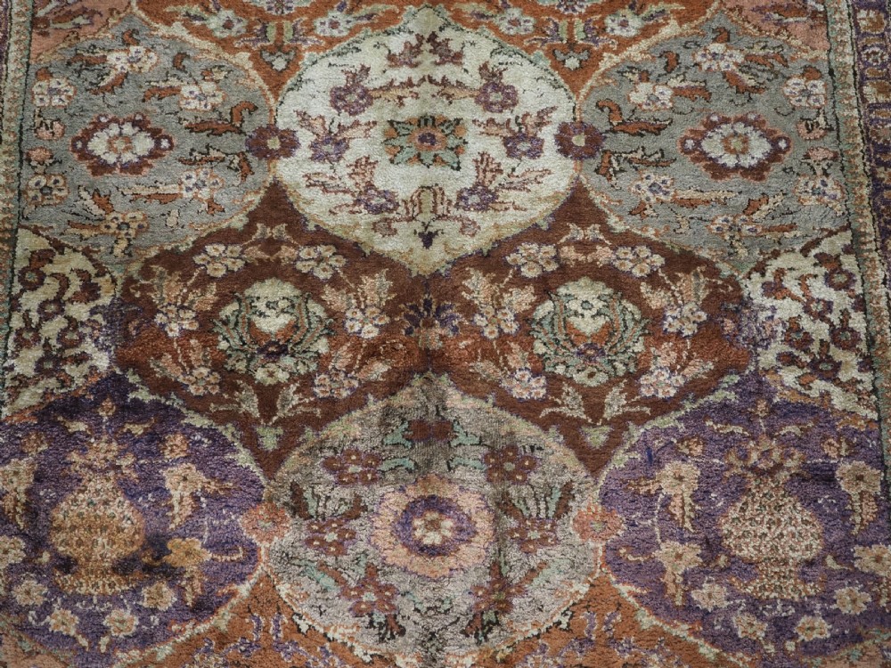 A rectangular vintage Turkish Kayseri rug featuring intricate floral lattice motifs and medallions in shades of brown, terracotta, purple, and green with a decorative bordered edge and fringed ends. View VIII