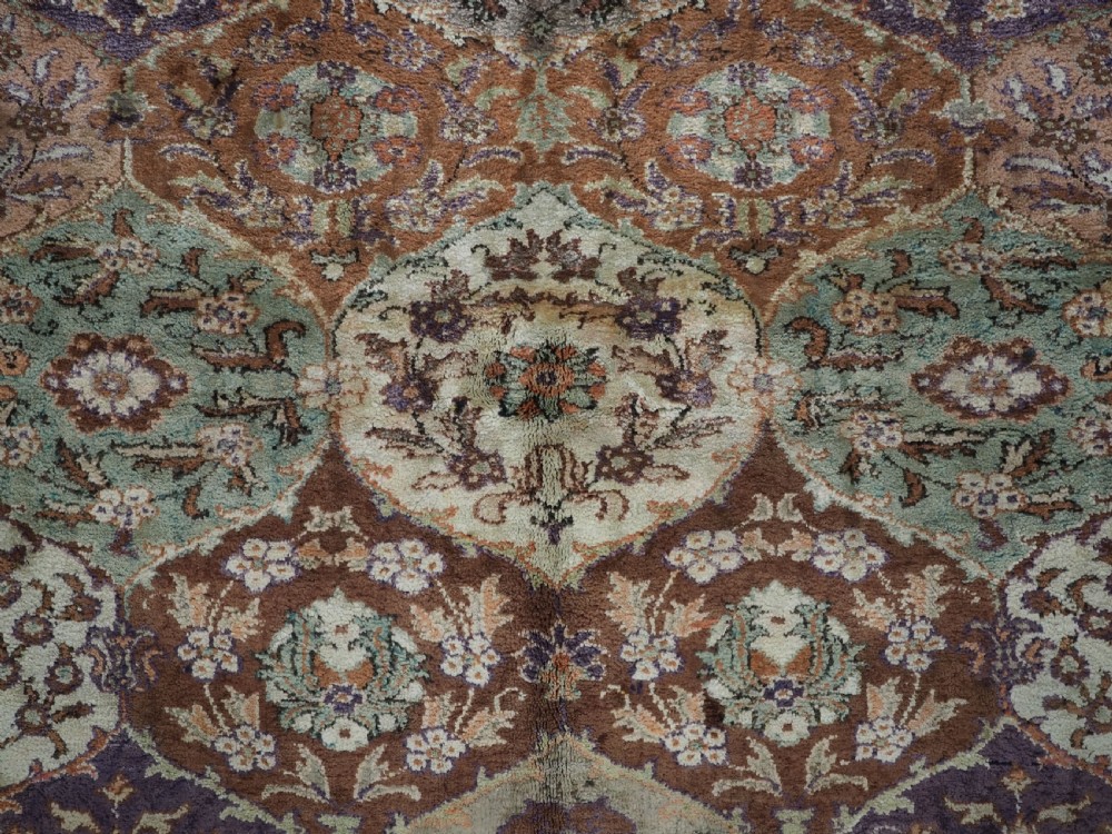 A rectangular vintage Turkish Kayseri rug featuring intricate floral lattice motifs and medallions in shades of brown, terracotta, purple, and green with a decorative bordered edge and fringed ends. View IX